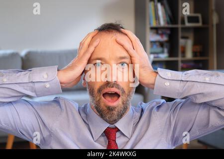 Mann mit Überraschung, Unglauben und Ehrfurcht. Bärtiger Mann mit Business-Shirt. Erwachsener kaukasischer Mann im Jahr 30s oder 40s. Stockfoto