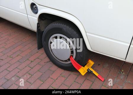 Radklemme an einem Lieferwagen in Köln, Deutschland. Unsachgemäße Radsperre des Parkwagens. Stockfoto