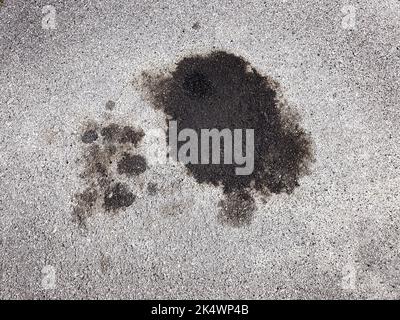 Ölpest aus dem Auto auf dem Parkplatz auf der Straße verschüttet Stockfoto