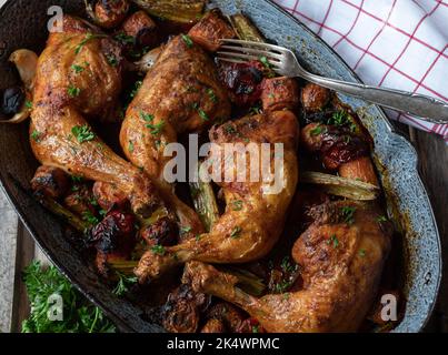 Geschmorte Hähnchenschenkel mit Wurzelgemüse in einer Bratpfanne Stockfoto