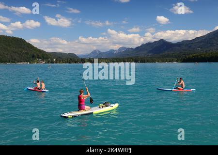 KÄRNTEN, ÖSTERREICH - 10. AUGUST 2022: Touristen genießen den Sommer am Faakersee (Faaker See) mit Blick auf das Karawanken-Gebirge (Karawanken) in der neuen Saison Stockfoto