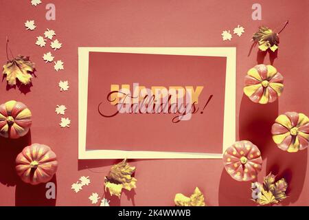 Dekorativer Rahmen mit braunen und orangen Herbstdekor. Monochromatischer Look mit bemalten Kürbissen und trockenen Herbstblättern. Flach liegend, Draufsicht, Text Happy Fall Stockfoto