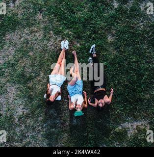 Vogelperspektive auf drei Frauen, die auf dem Gras liegen Stockfoto