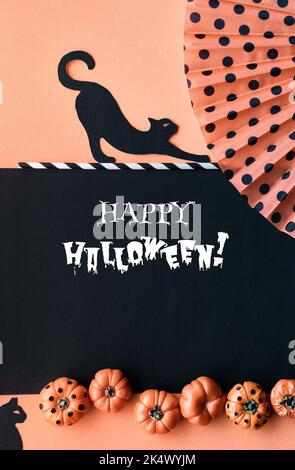 Niedliche Halloween vertikalen Hintergrund, Vorlage für Social-Media-Geschichten. Schwarze Katzen, bemalte Deko-Kürbisse und Fächer mit Tupfen. Orange, schwarz Stockfoto