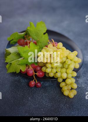 Weinlese im Herbst. Ernte und Saft, rote und grüne Bio-Trauben auf dem Tisch von oben betrachtet, Konzeptwein Stockfoto