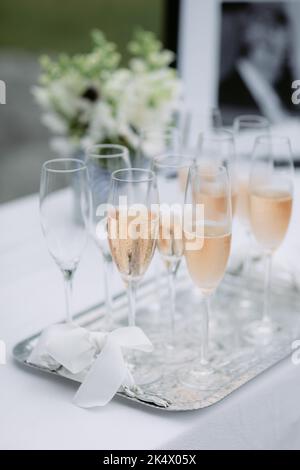 Rosafarbener Champagner in Flöten auf einem silbernen Tablett bei einer Hochzeit Stockfoto