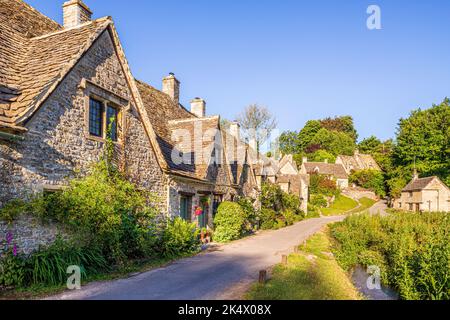 Im Hochsommerlicht am frühen Morgen in der Arlington Row im Cotswold-Dorf Bibury, Gloucestershire, England Stockfoto