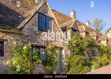 Im Hochsommerlicht am frühen Morgen in der Arlington Row im Cotswold-Dorf Bibury, Gloucestershire, England Stockfoto