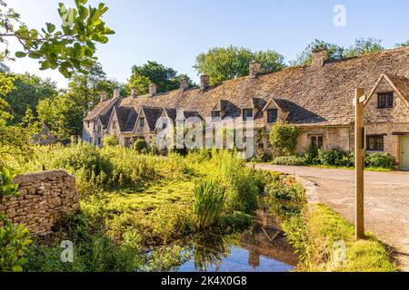 Im Hochsommerlicht am frühen Morgen in der Arlington Row im Cotswold-Dorf Bibury, Gloucestershire, England Stockfoto