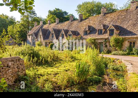 Im Hochsommerlicht am frühen Morgen in der Arlington Row im Cotswold-Dorf Bibury, Gloucestershire, England Stockfoto