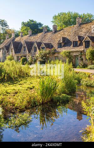 Im Hochsommerlicht am frühen Morgen in der Arlington Row im Cotswold-Dorf Bibury, Gloucestershire, England Stockfoto