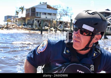 Nach dem US-amerikanischen „Gulf Strike Team“, dem „Gulf Strike Team“ der US-Küstenwache, durchreist Hunter Gaines am 2. Oktober 2022 Matlacha, Florida, die Gewässer. Die Küstenwache arbeitete mit staatlichen und lokalen Behörden sowie guten Samaritanern zusammen, um sicherzustellen, dass die Bewohner von Pine Island nach dem Hurrikan Transport zum Festland sowie Zugang zu sauberem Wasser und Lebensmitteln hatten. Stockfoto