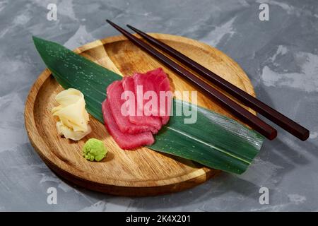 Japanische Küche, Ansicht von oben auf Bambusblättern, Thunfisch-Sashimi ist traditionell japanisch, selektiver Fokus, Fischscheiben von oben Stockfoto