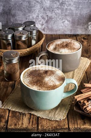 Caffe Latte mit Zimtpulver serviert in einem gemütlichen Café. Stockfoto