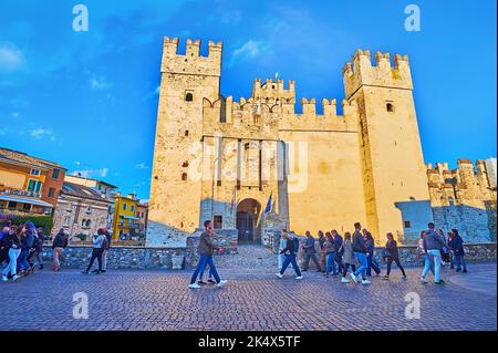 SIRMIONE, ITALIEN - 10. APRIL 2022: Fassade aus mittelalterlichem Stein Scaligero Castle mit Tor, Wall und Türmen, am 10. April in Sirmione Stockfoto