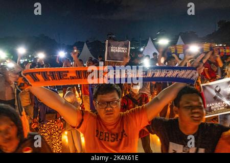 Kendari, Indonesien. 04. Oktober 2022. Ein Unterstützer von Persija Jakarta, der die Rivalen von Arema sind, stellt Shal Arema und Persija als eine Form der Wertschätzung während der Gebetsandacht an die Opfer des Kanjuruhan-Stadions dar. Die Kendari City Football Supporting Community hielt ein Gebet für die Anhänger des Malang Arema Clubs ab, die bei der Tragödie im Kanjuruhan Stadium, Malang, ums Leben kamen. (Foto von Andry Denisah/SOPA Images/Sipa USA) Quelle: SIPA USA/Alamy Live News Stockfoto