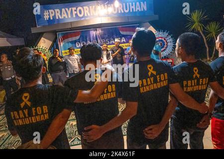 Kendari, Indonesien. 04. Oktober 2022. Fußballfans kommen zusammen, wenn sie ein Lied singen, um die Opfer der Tragödie im Kanjuruhan-Stadion zu würdigen. Die Kendari City Football Supporting Community hielt ein Gebet für die Anhänger des Malang Arema Clubs ab, die bei der Tragödie im Kanjuruhan Stadium, Malang, ums Leben kamen. (Foto von Andry Denisah/SOPA Images/Sipa USA) Quelle: SIPA USA/Alamy Live News Stockfoto