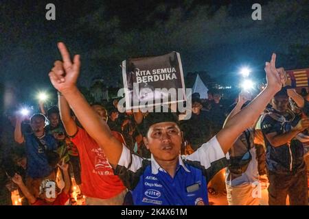 Kendari, Indonesien. 04. Oktober 2022. Ein Fußballfan wird während des Kerzenlicht-Gebets zu Ehren derer gesehen, die bei der Tragödie im Kanjuruhan-Stadion ums Leben kamen. Die Kendari City Football Supporting Community hielt ein Gebet für die Anhänger des Malang Arema Clubs ab, die bei der Tragödie im Kanjuruhan Stadium, Malang, ums Leben kamen. (Foto von Andry Denisah/SOPA Images/Sipa USA) Quelle: SIPA USA/Alamy Live News Stockfoto