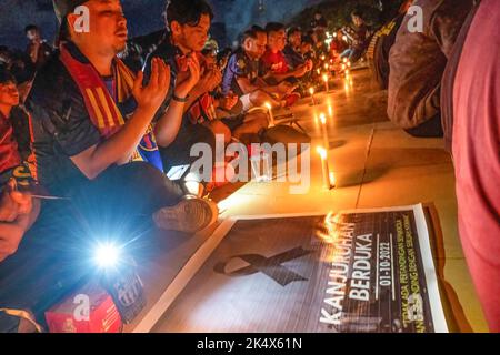 Kendari, Indonesien. 04. Oktober 2022. Fußballfans beten für die Opfer der Tragödie im Kanjuruhan-Stadion. Die Kendari City Football Supporting Community hielt ein Gebet für die Anhänger des Malang Arema Clubs ab, die bei der Tragödie im Kanjuruhan Stadium, Malang, ums Leben kamen. (Foto von Andry Denisah/SOPA Images/Sipa USA) Quelle: SIPA USA/Alamy Live News Stockfoto