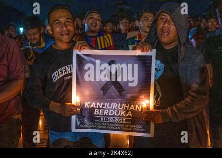 Kendari, Indonesien. 04. Oktober 2022. Fußballfans halten ein Banner mit einem schwarzen Band in Ehren der Opfer der Tragödie im Kanjuruhan-Stadion. Die Kendari City Football Supporting Community hielt ein Gebet für die Anhänger des Malang Arema Clubs ab, die bei der Tragödie im Kanjuruhan Stadium, Malang, ums Leben kamen. (Foto von Andry Denisah/SOPA Images/Sipa USA) Quelle: SIPA USA/Alamy Live News Stockfoto