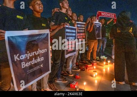 Kendari, Indonesien. 04. Oktober 2022. Fußballfans halten Plakate, während sie an einem Kerzenlicht-Gebet zu Ehren derer teilnehmen, die bei der Tragödie im Kanjuruhan-Stadion ums Leben kamen. Die Kendari City Football Supporting Community hielt ein Gebet für die Anhänger des Malang Arema Clubs ab, die bei der Tragödie im Kanjuruhan Stadium, Malang, ums Leben kamen. (Foto von Andry Denisah/SOPA Images/Sipa USA) Quelle: SIPA USA/Alamy Live News Stockfoto