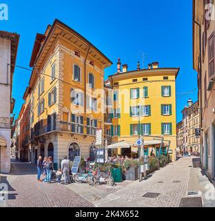 BRESCIA, ITALIEN - 10. APRIL 2022: Die mittelalterlichen schäbigen Häuser mit Cafés und Bars, Via Gasparo da Salo Straße, am 10. April in Brescia Stockfoto