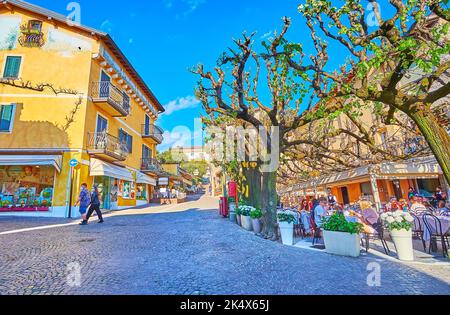 SIRMIONE, ITALIEN - 10. APRIL 2022: Die Außenrestaurants und farbigen Gebäude auf der Piazza Porto Valentino, am 10. April in Sirmione Stockfoto