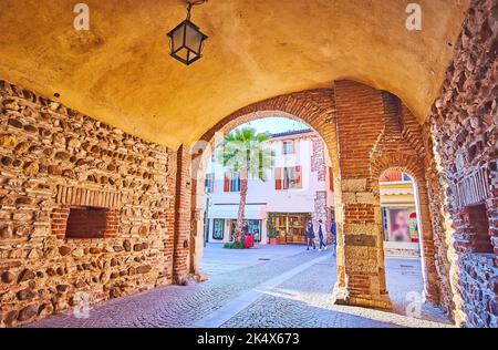 Der steinerne Bogengang führt durch das alte Haus in der Altstadt von Sirmione, Italien Stockfoto