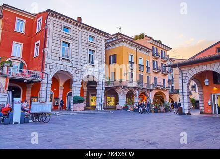 DESENZANO DEL GARDA, ITALIEN - 10. APRIL 2022: Abendansicht des Giuseppe-Malvezzi-Platzes mit historischen Wohnhäusern, Restaurants und Geschäften im Freien am Apr Stockfoto