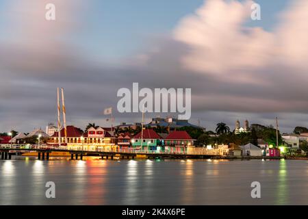 Farbenfrohe Gebäude des Einkaufsviertels Heritage Quay spiegeln sich in der Abenddämmerung im Meer wider, St. John's, Antigua, Karibik, westindien Stockfoto