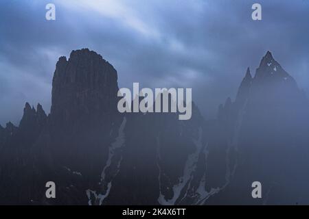 Wolkiger Himmel in der Abenddämmerung über Cadini di Misurina, der aus Nebel, Dolomiten, Venetien, Italien auftaucht Stockfoto