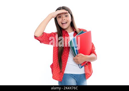 Schulmädchen mit Buch kopieren posiert auf isoliertem Hintergrund. Literaturunterricht, Gymnasium. Intellektueller Kinderleser. Porträt von glücklichen Lächeln Stockfoto