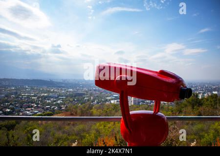 Rotes Fernglas auf dem Panorama der Stadt Stockfoto