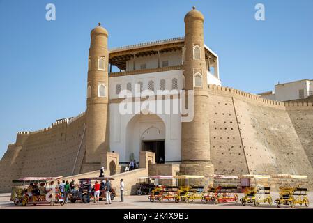 BUCHARA, USBEKISTAN - 09. SEPTEMBER 2022: Fahrradautos mit Touristen auf der alten Arche-Festung. Buchara, Usbekistan Stockfoto