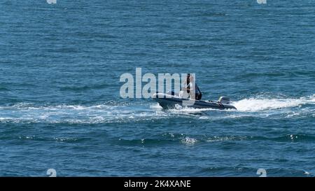 County Cork, Irland, 28. Mai 2022. Zwei Männer in einem Motorboot segeln an einem sonnigen Frühlingstag auf blauem Meer. Stockfoto