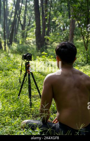 Millennial Kerl meditieren mit Trainer online über Tablet ipad-Verbindung, im Wald, online senden Ihre Klasse und Anweisungen, mexiko Stockfoto