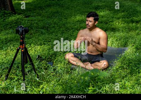 Ansicht eines Mannes, der mit einer Gruppe von Menschen zu Hause einen virtuellen Fitnesskurs durchführt, auf einer Videokonferenz. Fitnesstrainer, der Online-Yoga-Kurse besucht Stockfoto