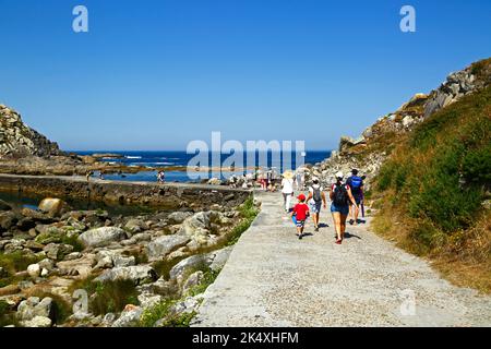 Touristen, die entlang des Damm über die Gezeitenlagune von Illa de Monteagudo nach Illa de Faro / Montefaro, Cies-Inseln, Galizien, Spanien, wandern. Stockfoto