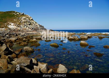 Blick über die flache, felsige Gezeitenlagune zwischen Illa de Monteagudo und Illa de Faro / Montefaro, Cies-Inseln, Galicien, Spanien. Stockfoto