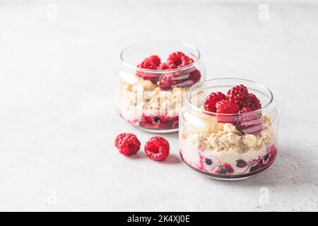 Über Nacht Haferflocken mit Himbeeren, Johannisbeeren und Tahini in Gläsern, Platz zum Kopieren. Gesundes Frühstückskonzept. Stockfoto