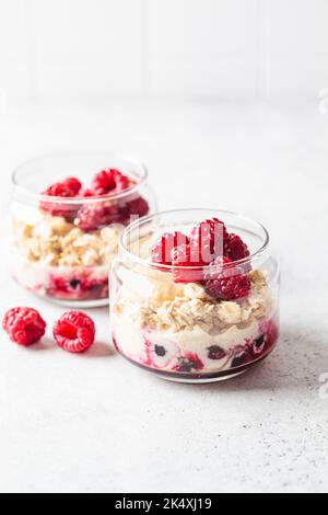 Über Nacht Haferflocken mit Himbeeren, Johannisbeeren und Tahini im Glas. Gesundes Frühstückskonzept. Stockfoto