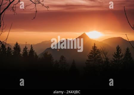Die letzte Sonne strahlt irgendwo in europa über einem wunderschönen Berggipfel Stockfoto