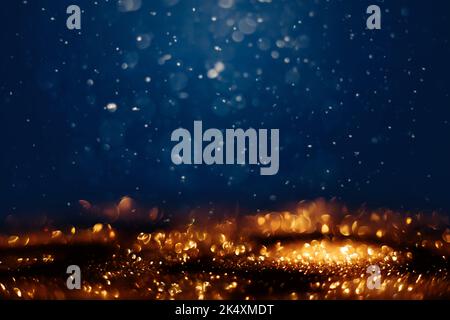 Leuchtet in der dunklen, unfokussierter goldener Glitzer-Textur. Weihnachten und Winterferien Hintergrund Stockfoto