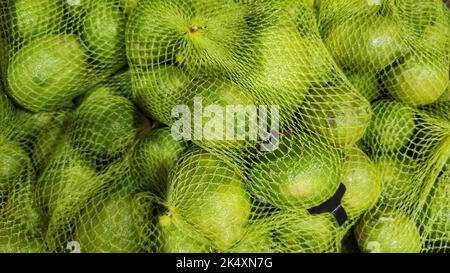 Zitronen im Netz auf gelbem Hintergrund Stockfoto