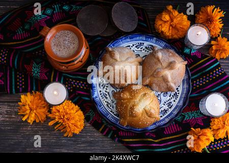 Mexikanisches Brot auf dem Altar mit Zuckerschädel und heißer Schokolade Traditionelles Essen zur Feier des mexikanischen Totentages Stockfoto