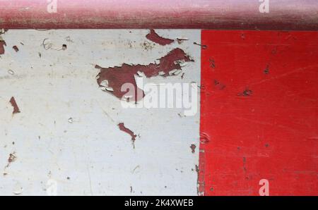 Hintergrund mit abblätternder roter und weißer Farbe auf dem Straßenschild Stockfoto