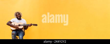 In voller Länge Foto von Angeregten künstlerische Mann, der seine Gitarre spielen. Auf gelben Hintergrund. Stockfoto