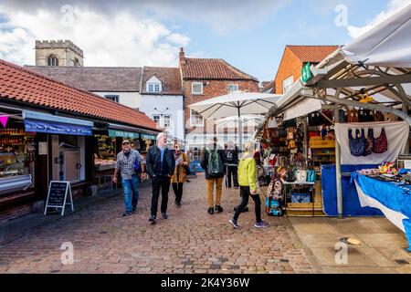 Shopper shoppen und spazieren durch den Shambles-Markt im Freien in der Stadt York Yorkshire, England. Stockfoto