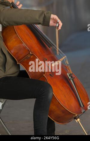 Nicht erkennbare Person, die auf der Straße Cello spielt. Paris Stockfoto