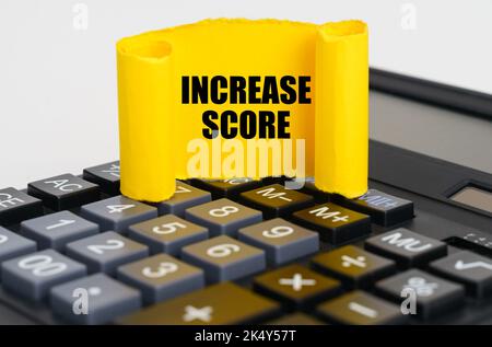 Geschäftskonzept. Auf dem Rechner befindet sich eine gelbe, verdrehte Papierplatte mit der Aufschrift - Erhöhen Sie die Punktzahl Stockfoto
